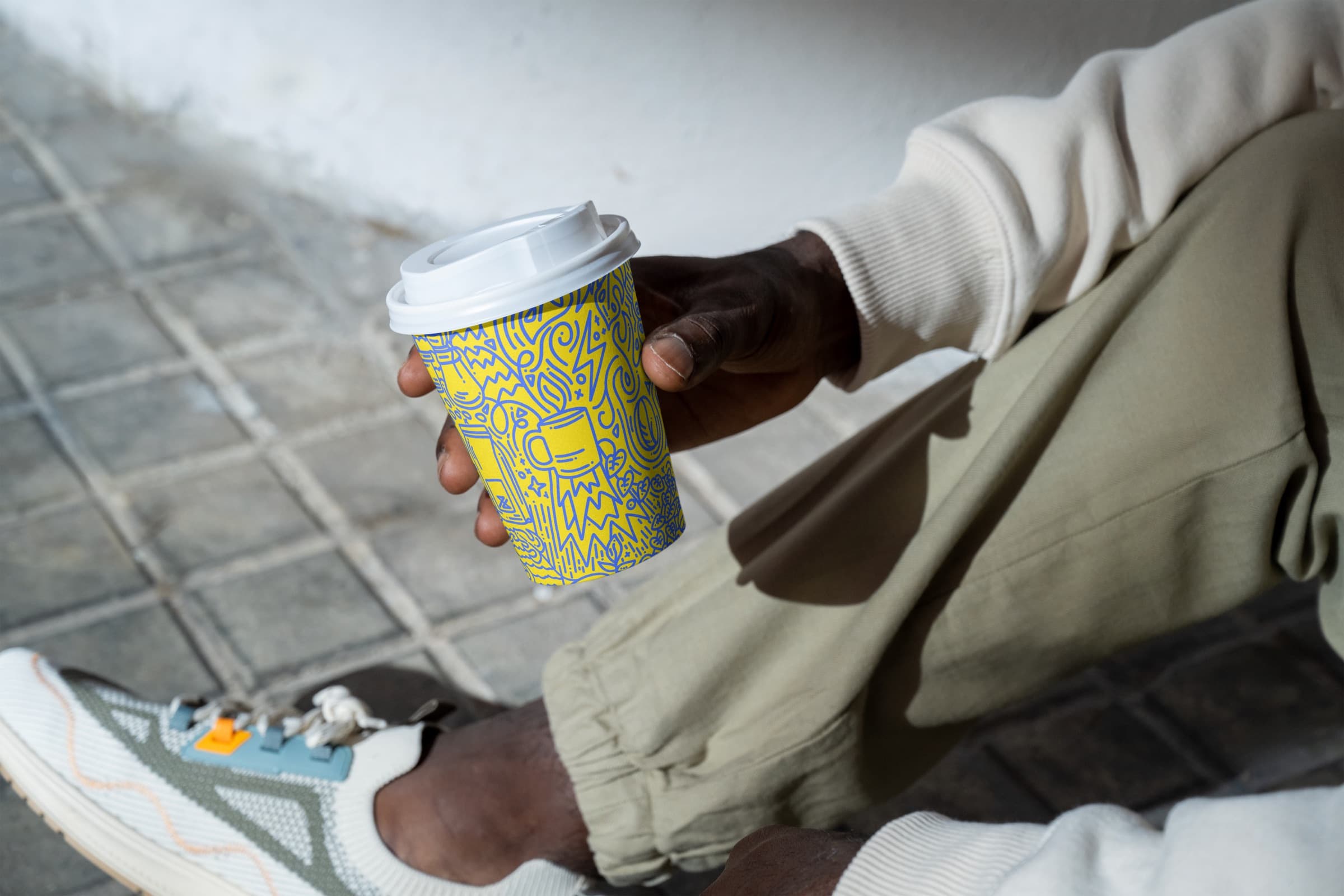 Hand holding a yellow Verde takeaway coffee cup
